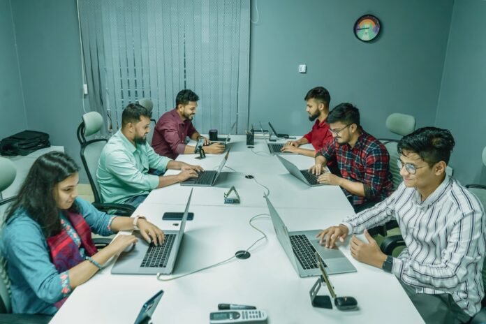 best-itsm-tools-for-small-business-featured a group of people sitting around a table with laptops