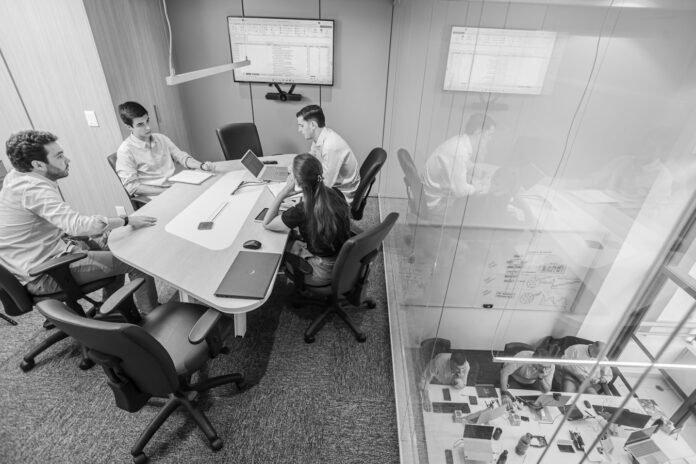 esm-use-cases-beyond-it-featured Team meeting in a modern conference room.