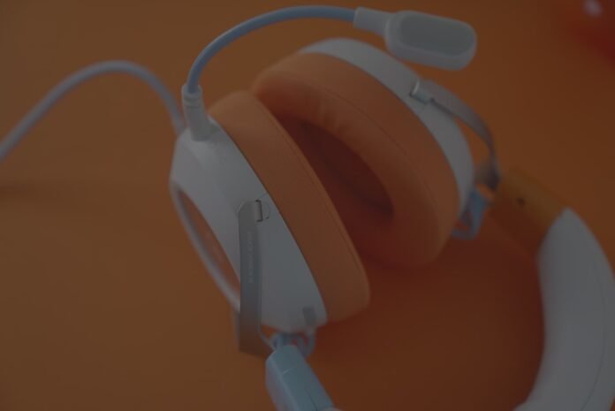 how-to-improve-help-desk-csat-featured Headphones with orange ear cushions and microphone.