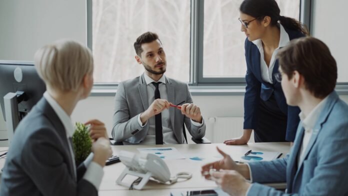 in-house-vs-outsourced-it-support-featured Business professionals collaborating around a conference table.
