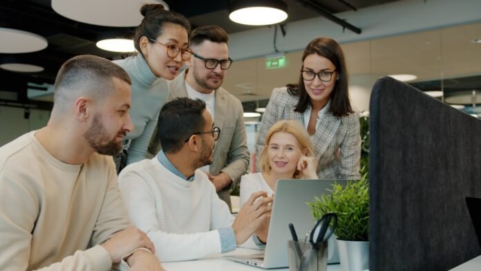 it-self-service-portal-best-practices-featured Diverse team collaborating around a laptop in office.